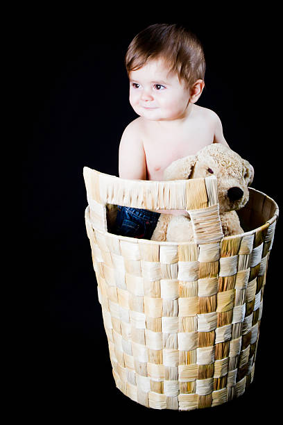 istock Baby boy in wicker basket with his puppet dog 153761590