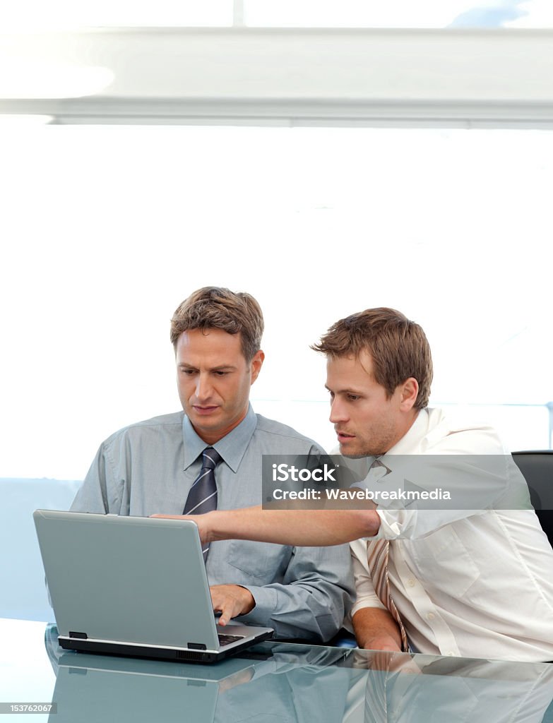 Dois parceiros trabalhando juntos em um laptop sentado - Foto de stock de Adulto royalty-free