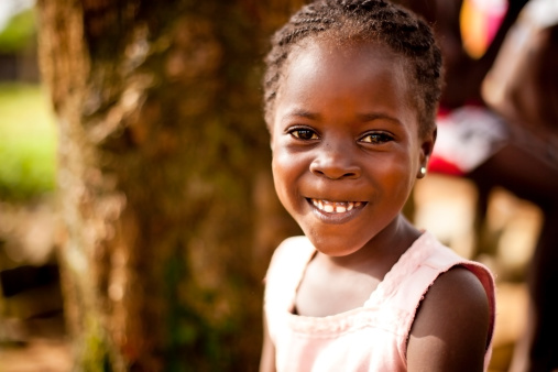 a young west african girl smiling happily 