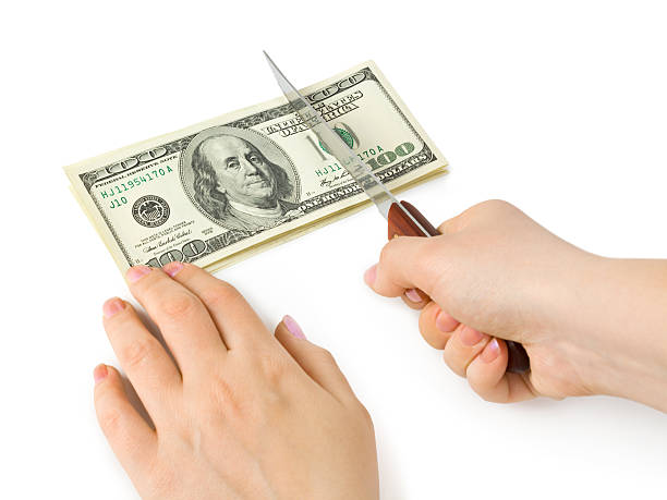 istock Hands with knife cutting money 153763730