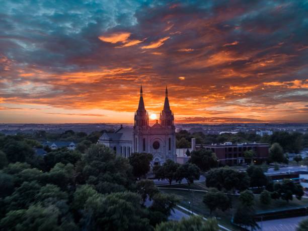 Sunset over an old Cathedral Sun in between two spires of an old Cathedral in the Midwest south dakota stock pictures, royalty-free photos & images