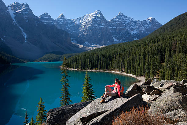 istock Woman with backpack sits on a rock at Moraine Lake, Canada 153765379