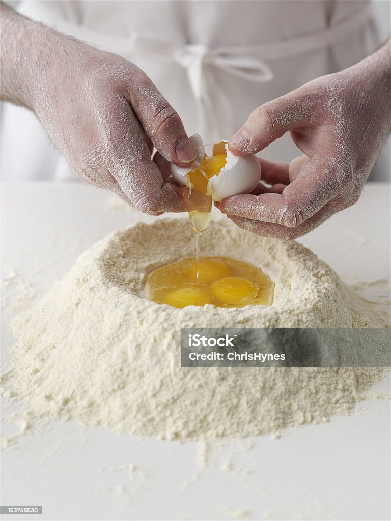 Kucharz pękanie jajek na mąkę - Zbiór zdjęć royalty-free (Kultura włoska)