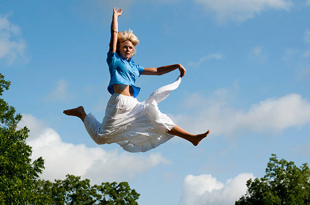 istock Carefree Young Woman Leaping for Joy Over Tree Tops 153765805