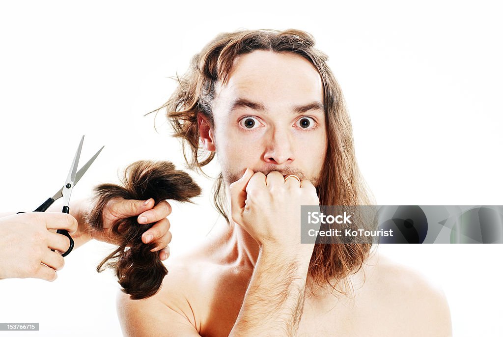 Bad haircut Young frightened man with long hair being terribly clipped Hairdresser Stock Photo