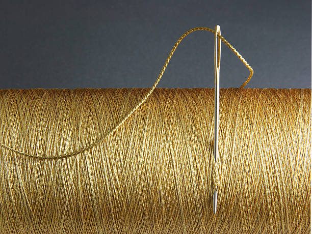 A needle stuck in a spool of thread