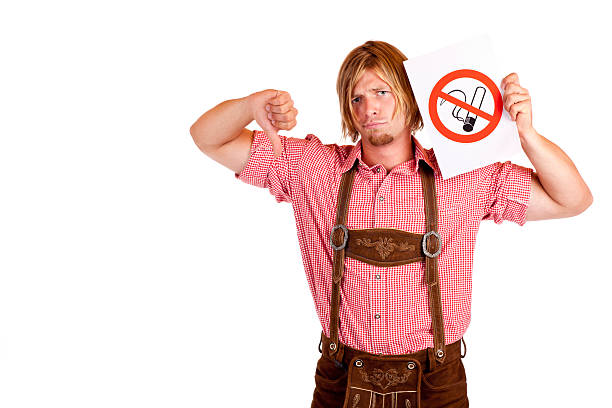 Sad Bavarian man in lederhose disagrees to non-smoking-rule stock photo