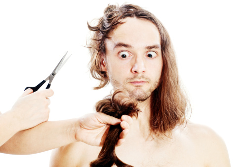 Young frightened man with long hair being terribly clipped