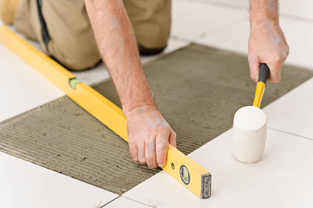 Home improvement, renovation - handyman laying tile stock photo