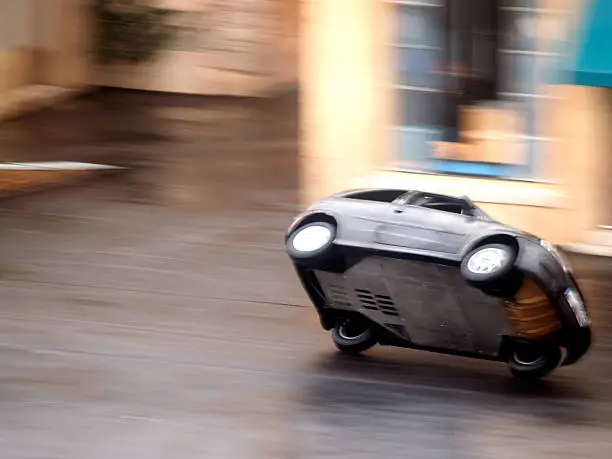 Stunt car speeding through town on two wheels.