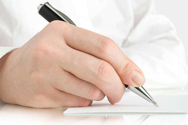 istock pen in hand writing on the page 153768111