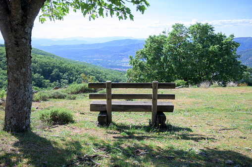 Wooden bench in the middle of nature with views of the mountains in the background of the valley