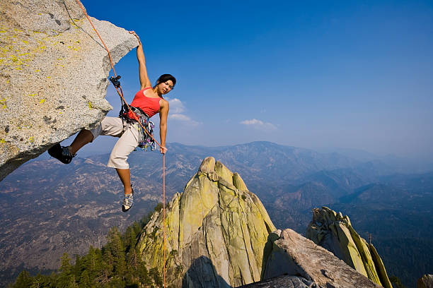 Female rock climber rappelling. stock photo