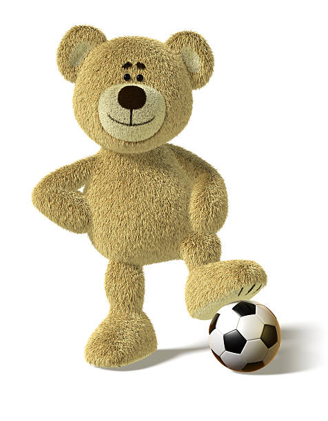 Teddy Bear smiles and stands with one foot on a soccer ball. His right hand on his hips in a cool champions pose. This image is isolated on a white background with soft shadows