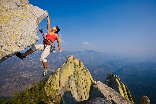 Picture of a female rock climber rappelling on mountain stock photo