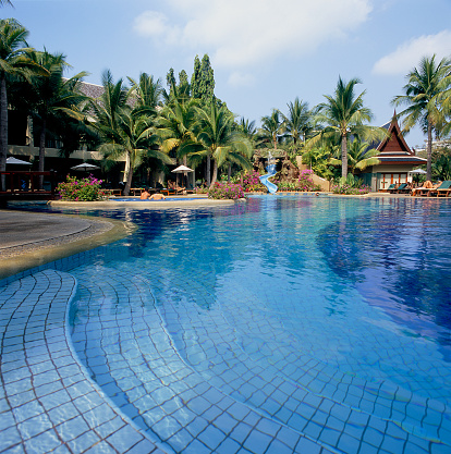 A big swimming pool in the tropical garden and Asian spa house