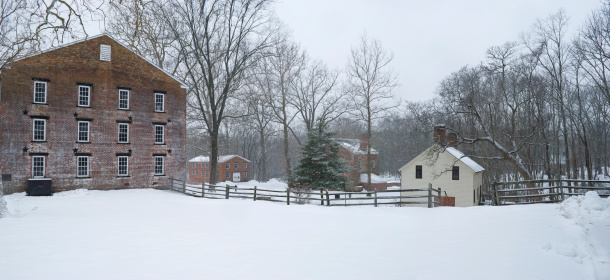 A snowy Winter panoramic view of the colonial buildings in Allaire State Park