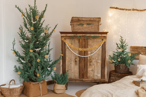 Cozy interior decorated for Christmas in Scandinavian style. Live fir trees decorated with natural ornaments made of dried oranges stock photo