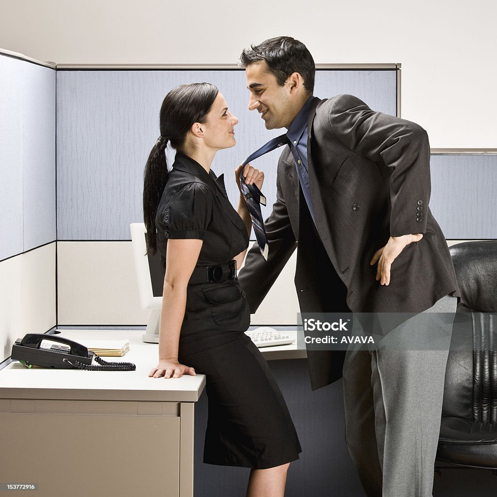 Co-workers Kissing in Office Cubicle Co-workers kissing in office cubicle. Square shot. Office Stock Photo