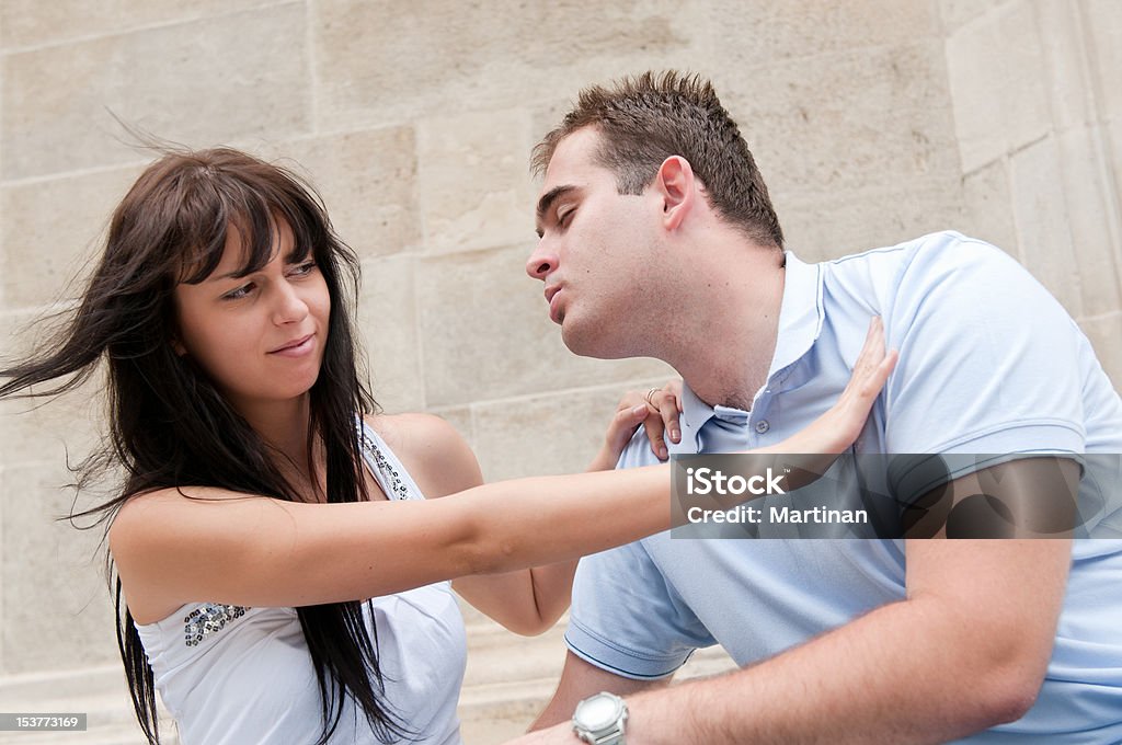Relationship problems - young couple outdoors Young couple having relationship problems - woman refuses kissing from man Kissing Stock Photo