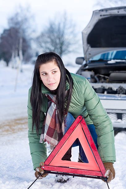 istock Winter car breakdown - woman warning triangle 153773172