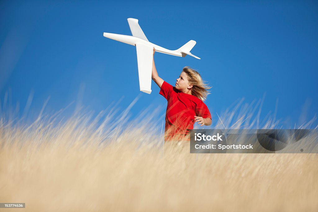 Jovem rapaz brincando com avião planador de brinquedo no campo - Royalty-free Campo agrícola Foto de stock