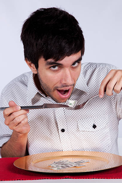 istock Man eating little dollar banknote 153774822