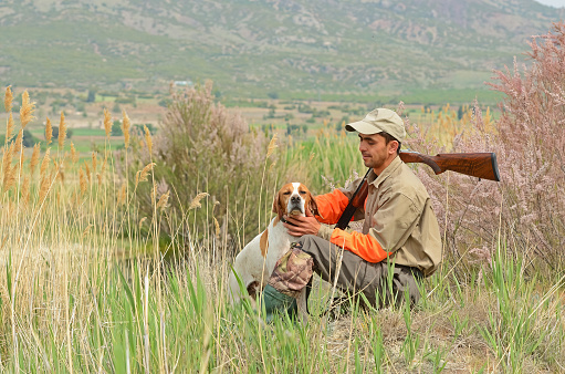 The hunter and the hunting dog are resting.