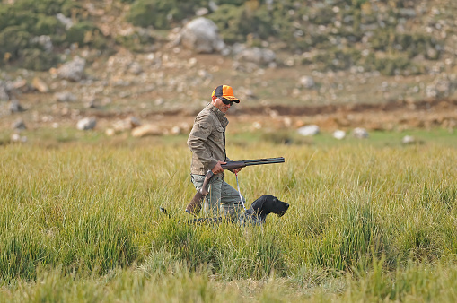The hunter and the hunting dog are hunting.