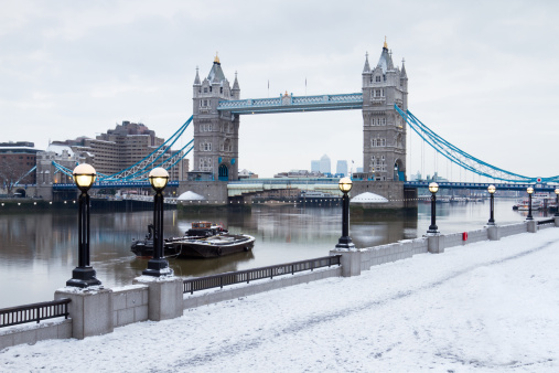 london tower bridge by river thames in snow