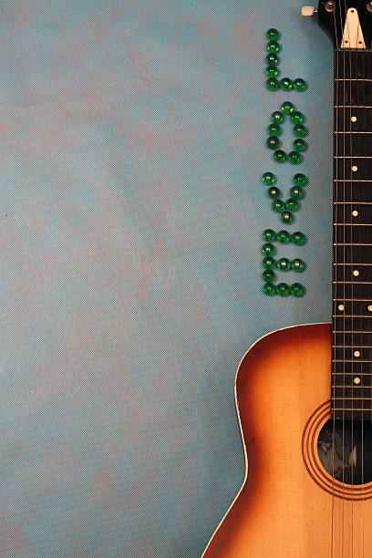 Acoustic Guitar Isolated On Blue With Love Word Stock Photo - Download  Image Now - Acoustic Guitar, Bead, Blue Background - iStock