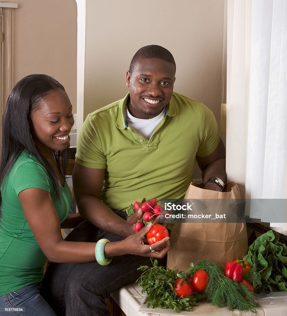 Young ethnic couple on kitchen sorting groceries 20-24 Years Stock Photo