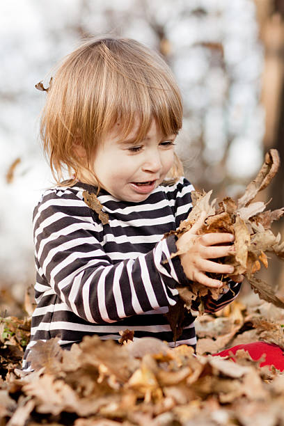 istock Cute little girl playing in autumn leafs 153775991