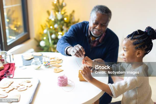 Grandfather And His Granddaughter Making Gingerbread House Stock Photo - Download Image Now