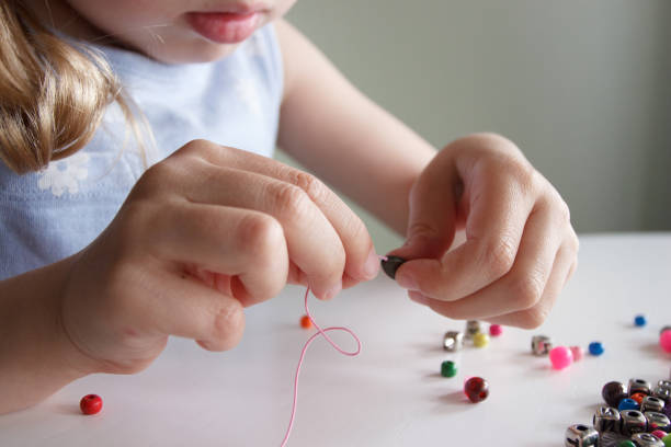 istock Process of making a bracelet from a thread and colored beads, concept of hobby 1537784628