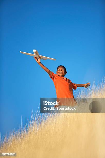 Ethnic Child Playing With Toy Glider Airplane In Field Stock Photo - Download Image Now