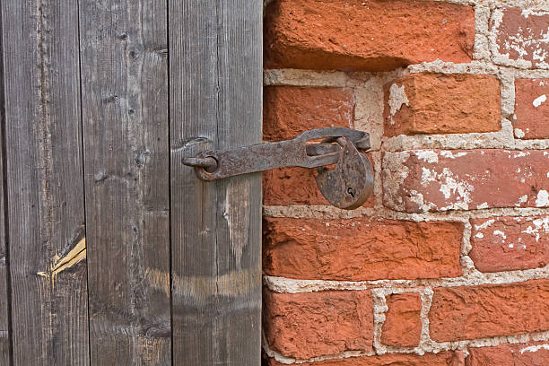 istock Old rusty check-lock on wooden door in brick wall. 153778947