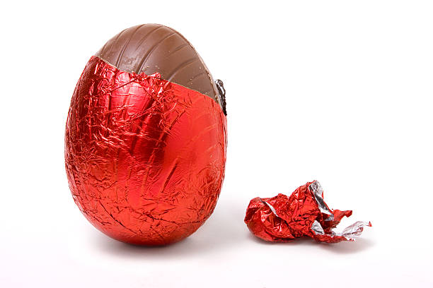 Easter egg covered in red foil on white background stock photo