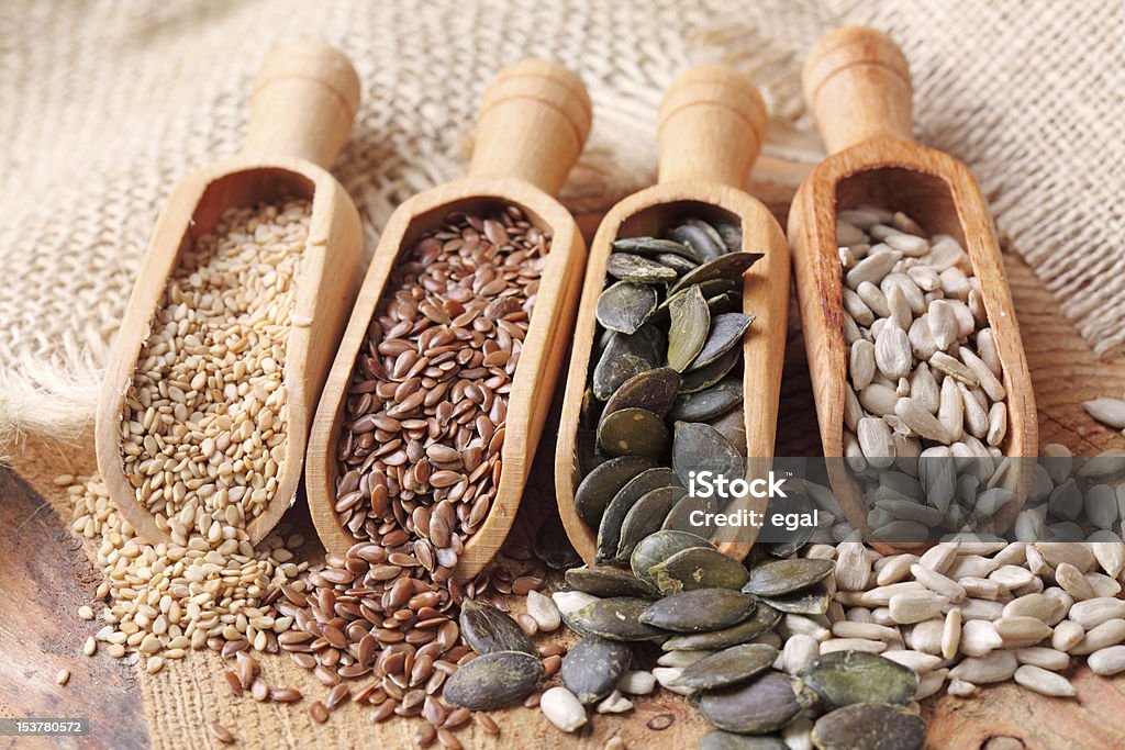 Sesame, flax, pumpkin and sunflower seeds Sesame, flax, pumpkin and sunflower seeds in wooden spoons Seed Stock Photo