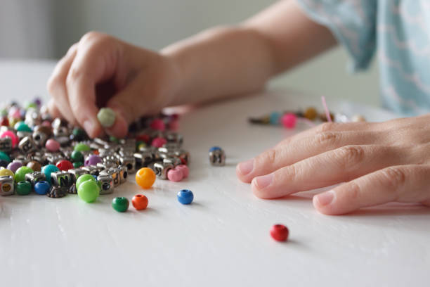 istock Process of making a bracelet from a thread and colored beads, concept of hobby 1537806184