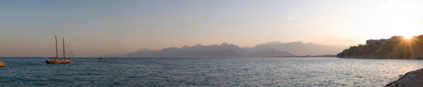 istock sea sunset with sailboat in bay 153780903