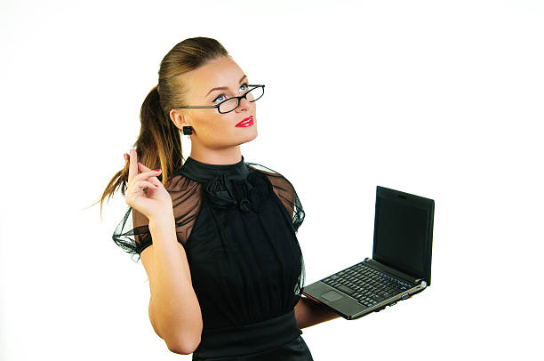 Woman in black dress with a laptop stock photo