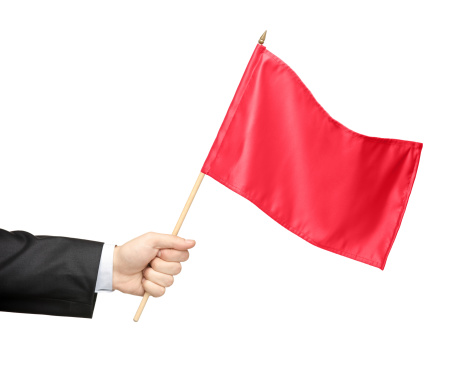 Hand holding a red flag isolated on white background