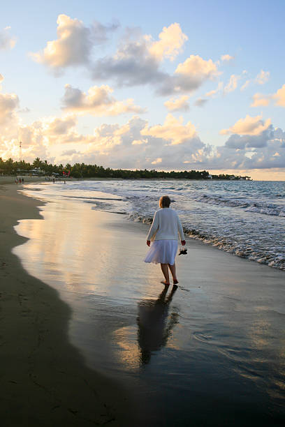 istock Senior Woman Walking Alone on Cararete Beach 153781826