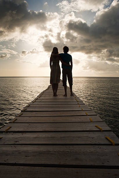 Young embracing couple watching sunset stock photo