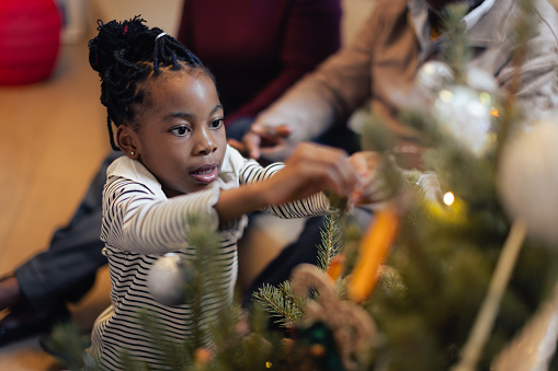 Christmas time. African American family spending time together. decorating Christmas tree