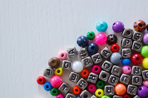 Background from different colored beads with numbers and symbols, top view