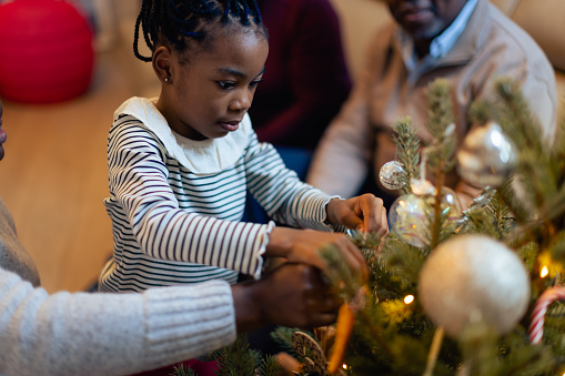 Christmas time. African American family spending time together. decorating Christmas tree