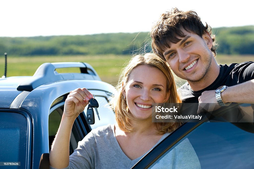 Szczęśliwa para w pobliżu nowego samochodu - Zbiór zdjęć royalty-free (20-29 lat)