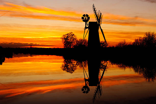 Sunset silhouette at How Hill, Ludham in Norfolk England. A traditional wind pump.